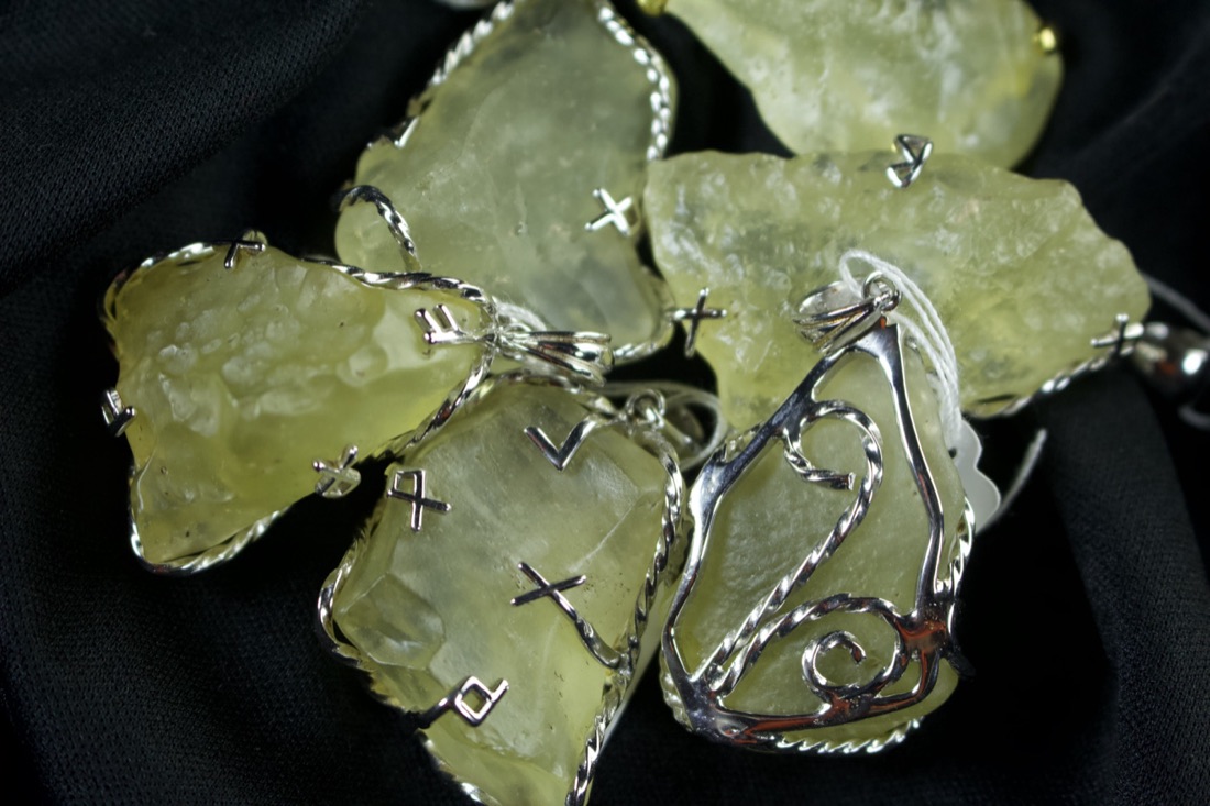 A group of silver wire-wrapped Libyan Desert Glass pendants