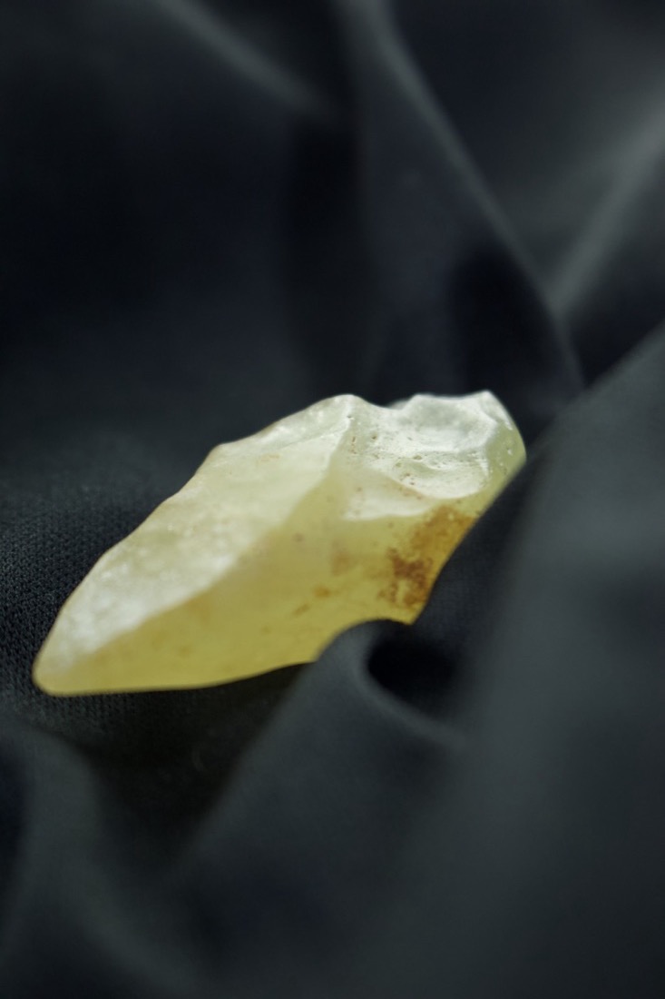 Libyan Desert Glass catching the light on black fabric