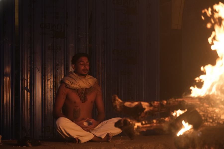 Arvin meditating beside a fire