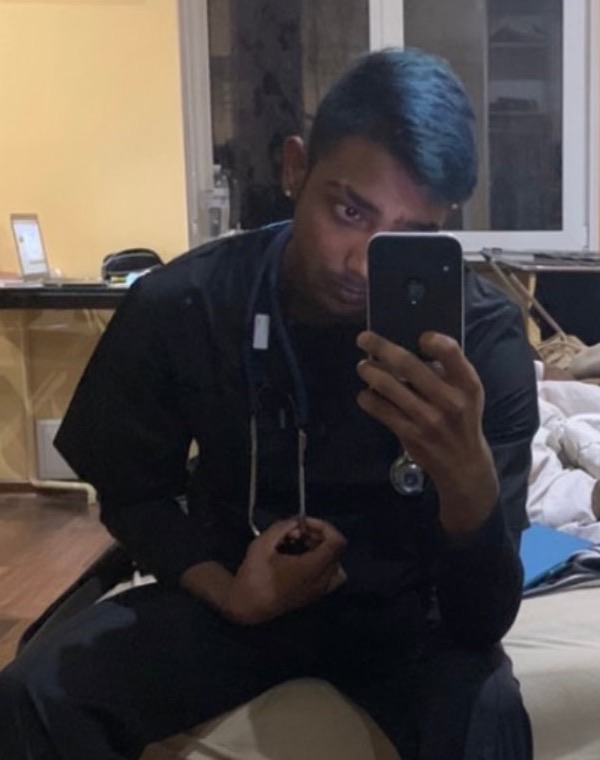 Arvin in medical scrubs with a stethoscope during medical school